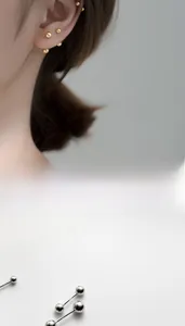 Détail macro des boucles d'oreilles boules minimalistes en argent S925, or et argent