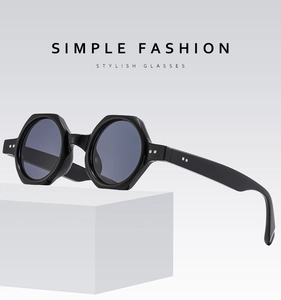 Close-up of black hexagonal sunglasses with metal rivets on premium frame