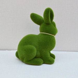 Close-up of green artificial moss rabbit figurine with soft flocked texture for Easter