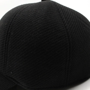 Close-up of black winter hat fabric with detailed stitching and thick honeycomb texture
