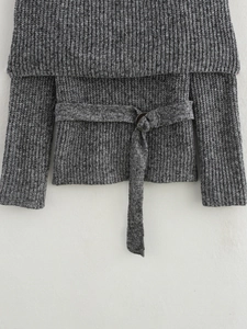 Dettaglio top grigio in maglia a costine scoperte con cintura in vita e fibbia in metallo