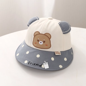 Détail des oreilles d'ours à pois et broderie sur un chapeau de soleil enfant