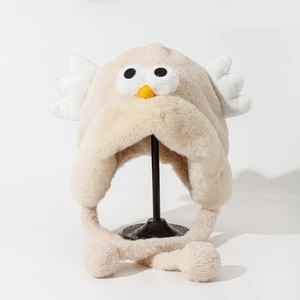 Detail of plush cartoon trapper hat with 3D eyes and wings on a clean white display