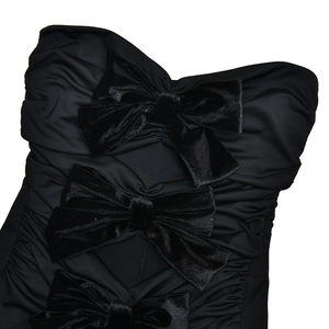 Detail of black strapless bodysuit featuring three velvet bows and side ruched texture