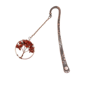 Macro shot of bronze Tree of Life bookmark with red crystal stones and metal chain