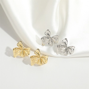 French vintage bow earrings in gold and silver with hollow mesh design on silk