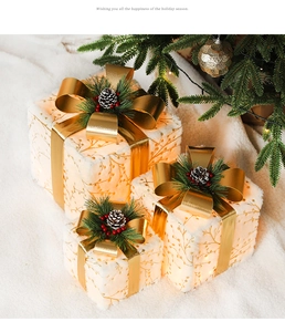 Three-piece set of lighted Christmas gift boxes with gold foliage and warm LED glow
