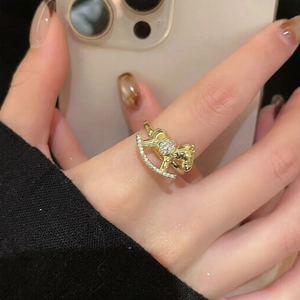 Detailed close-up of a golden rocking horse ring with sparkling white zircon stones