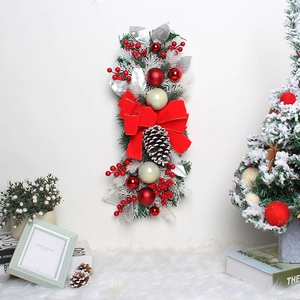 Detail of festive Christmas swag with red berries, pine cones and a large red bow