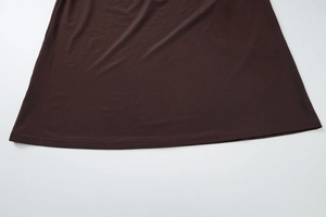 Gros plan détaillé du tissu en maille marron foncé et des coutures de la robe ajustée