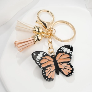 Detail of acrylic butterfly keychain with orange accents and soft decorative tassels