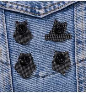 Close-up of heart cat pin backs with rubber clutches on blue denim jacket pocket