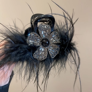 Détail d'une élégante pince à cheveux en acrylique noir avec strass et plumes