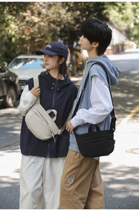 Outdoor shot of minimalist cream and black nylon crossbody bags for daily use