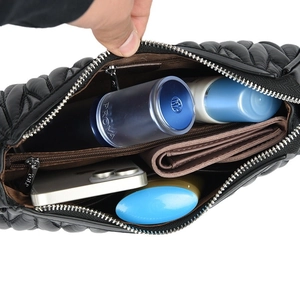 Black quilted crossbody bag with wave stitching showing spacious interior capacity