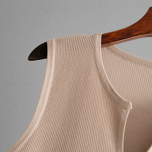 Detail of khaki ribbed knit tank top neckline and shoulder on a wooden hanger