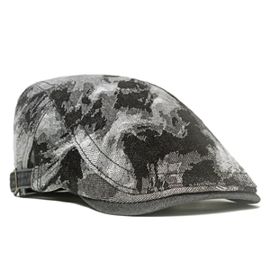 Dettaglio cappello newsboy in denim lavato con motivo jacquard e fibbia in metallo dorato