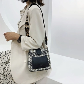 Detail of tweed and leather patchwork bucket bag with patterned wide shoulder strap