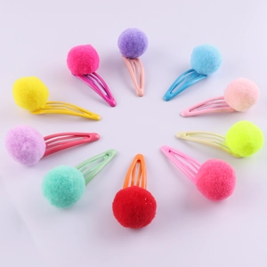 Set of ten colorful plush pom pom hair clips for children in a vibrant circular layout