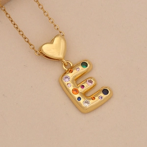 Detail of colorful zircon letter E pendant with a golden heart-shaped bail on chain