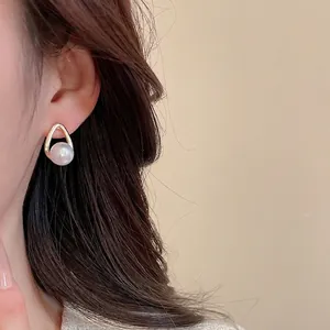 French vintage gold U-shaped earrings with round pearl on ear model