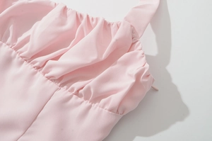 Détail de la robe licou rose avec plis fins et texture de surface en tissu tissé