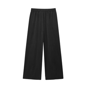 Detail view of black wide-leg trousers featuring elastic waistband and silky fabric texture