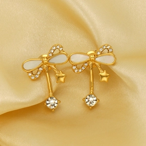 Elegant gold bow earrings with shimmering stars and rhinestones on satin background