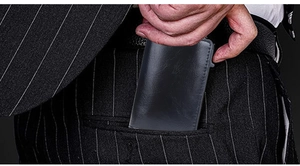 Slim black leather RFID wallet sliding easily into a suit trouser pocket for men
