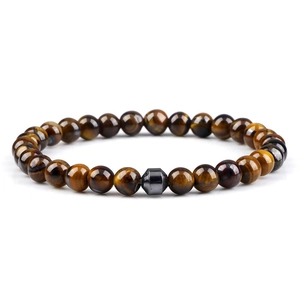 Macro detail of natural tiger eye beads and grey hexagonal hematite on elastic bracelet