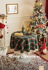 Detail of red and green Christmas plaid tablecloth with white fringe and festive decor