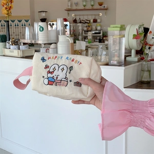Detail der beigen Cordtasche mit Kaninchenbestickung und rosa gewebtem Griff