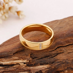 Bague en acier titane poli avec trois zircons micro-sertis sur fond de bois naturel