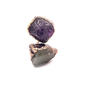 Macro shot of dual amethyst and green fluorite raw gemstones on golden adjustable band