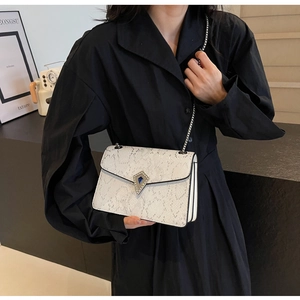White snake skin textured crossbody bag with metal chain strap and luxury buckle