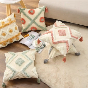 Tufted cotton linen cushion covers with geometric patterns and tassels on a sofa