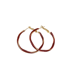 Twisted gold hoop earrings with dark red enamel coating in a minimalist retro style
