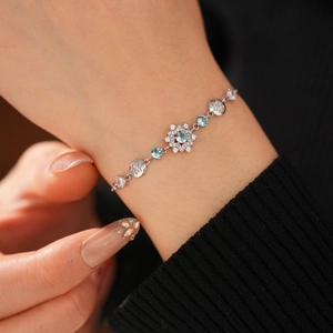 Detail of silver snowflake bracelet with blue crystals and zircon on woman's wrist
