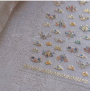 Macro detail of Chinese style nail art stickers with gold embossed traditional patterns