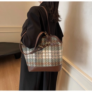 Detail of coffee plaid tote bag showing tweed fabric texture and golden metal hardware