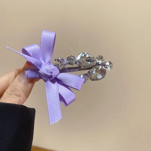 Détail de la pince à cheveux en satin violet avec cinq strass en cristal étincelants