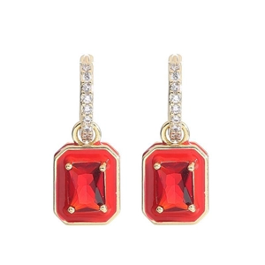 Detail of 18K gold earrings featuring rectangular red gemstones and small clear zircons