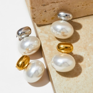 French retro pearl stud earrings with gold and silver metal beads on textured stone