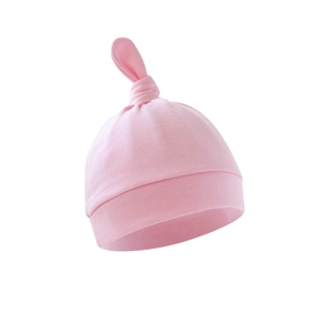Detail shot of a soft pink cotton baby top knot hat with a stylish folded brim design