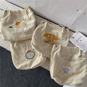 Détail de sacs cabas en velours côtelé crème avec des broderies mignonnes et tissu doux