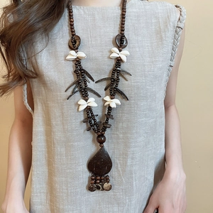 Detail of bohemian necklace with coconut shell beads and a large teardrop wooden pendant