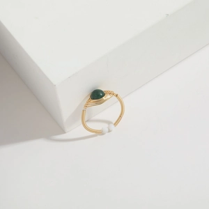 Detail of handmade wire-wrapped 14K gold ring with green gemstone and white beads