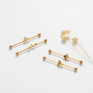 Golden stainless steel industrial barbell set with crown and snake shapes on white background