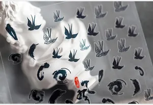 Macro detail of ink-style nail stickers featuring swallows and Chinese clouds