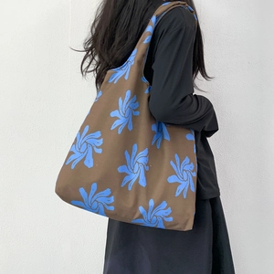 Side view of large canvas tote bag with blue floral print on dark brown fabric